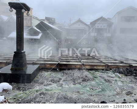 Snow scenery of the Yubatake and steam from the hot springs at Kusatsu Onsen 126835579