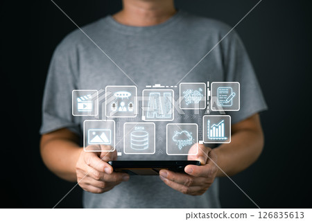 A man holds an AI icon while using a mobile, representing marketers who conduct research and analysis on media, focus on content creation, and develop strategies to grow their digital business. 126835613