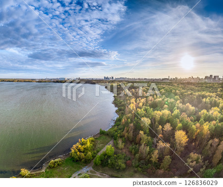 Autumn forest on lake shore at sunset and city on horizon, auerial view Autumn forest on lake shore at sunset and city on horizon, auerial view 126836029