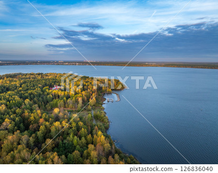 Autumn forest on lake shore at sunset and city on horizon, auerial view 126836040