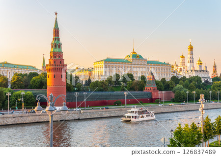 View of Kremlin with Vodovzvodnaya tower, Grand Kremlin Palace from repaired Bolshoy Kamenny Bridge in Moscow city on sunny summer day. Cruise ship sails on the Moscow river 126837489