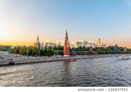 View of Kremlin with Vodovzvodnaya tower, Grand Kremlin Palace from repaired Bolshoy Kamenny Bridge in Moscow city on sunny summer day. Cruise ship sails on the Moscow river 126837491