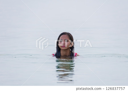 young asian woman enjoying swimming and smiling in shallow water of sea 126837757