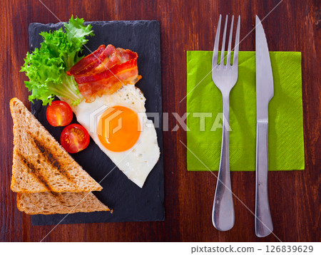 Top view of fried egg, bacon and grilled bread Top view of fried egg, bacon and grilled bread 126839629