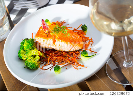 Tasty fried salmon on a pillow of smoked carrots, broccoli and fig on plate Tasty fried salmon on a pillow of smoked carrots, broccoli and fig on plate 126839673