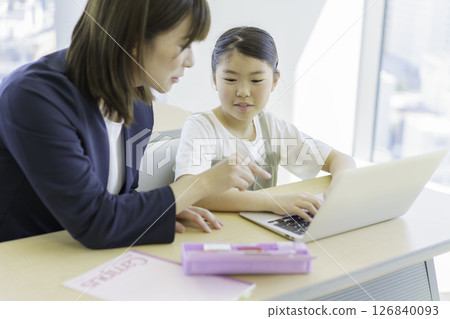 Elementary school girl and teacher studying on a laptop at a cram school. Photo courtesy of Tokyo Electronics College of Denpa Gakuen, a private school corporation. Elementary school girl and teacher studying on a laptop at a cram school. Photo courtesy of Tokyo Electronics College of Denpa Gakuen, a private school corporation. 126840093