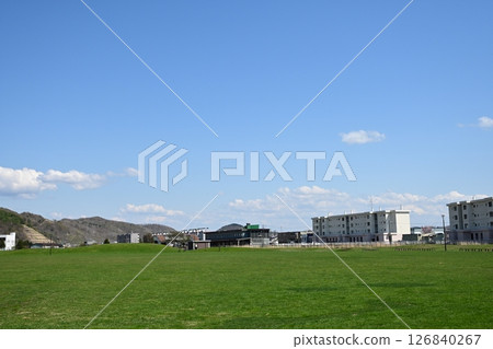 A grassy park overlooking an abandoned railway station 126840267