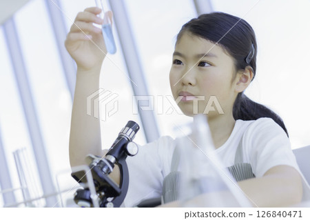 Elementary school girl looking at a test tube. Photo courtesy of Tokyo Electronics College, Denpa Gakuen Corporation. 126840471
