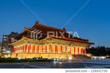The National Theater in Taipei, Taiwan glows under evening lights, its vibrant red columns and ornate roof standing out against a deep blue sky in Liberty Square 126841730