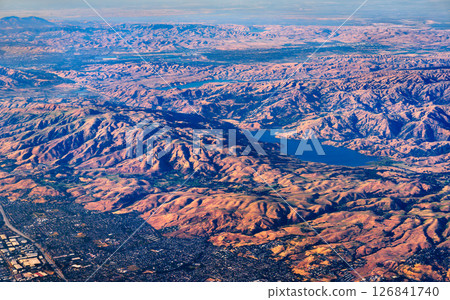 Sweeping aerial view of Calaveras Reservoir in California, surrounded by rolling hills and ridges of the Diablo Range with suburban areas visible on the edge of the frame Sweeping aerial view of Calaveras Reservoir in California, surrounded by rolling hills and ridges of the Diablo Range with suburban areas visible on the edge of the frame 126841740