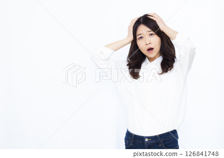 A surprised woman holding her head 126841748