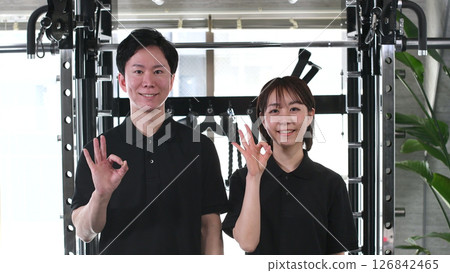 Gym instructor male and female doing OK Gym instructor male and female doing OK 126842465