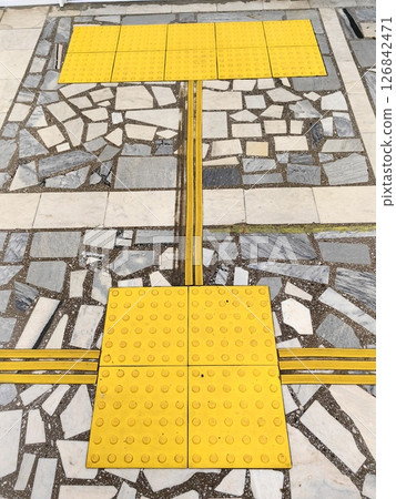 textured pavement with tactile guiding strips in public space for accessibility. textured pavement with tactile guiding strips in public space for accessibility. 126842471
