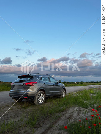 SUV on Rural Road with Poppies and Blue Sky 126843424