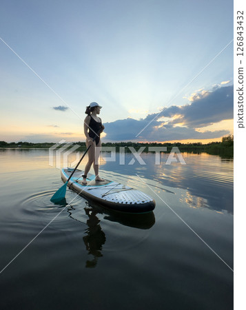 Paddleboarding at Sunset on a Tranquil Lake 126843432