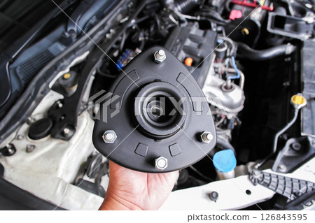 Shock Absorber Strut Mount in mechanic hand. 126843595