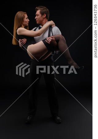 Couple performing an intimate dance in a dark studio setting at night 126843736