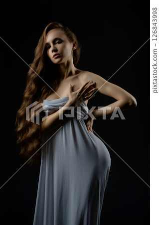 Model poses gracefully in a flowing gown for casting session in studio 126843998
