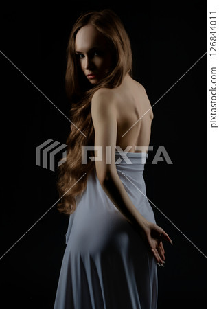 Model poses elegantly in a casting session with a dramatic backdrop 126844011