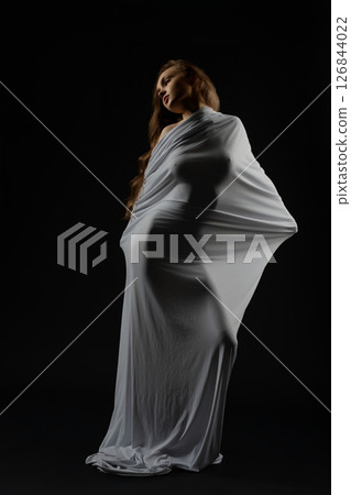 Model posing gracefully in flowing fabric during casting session 126844022