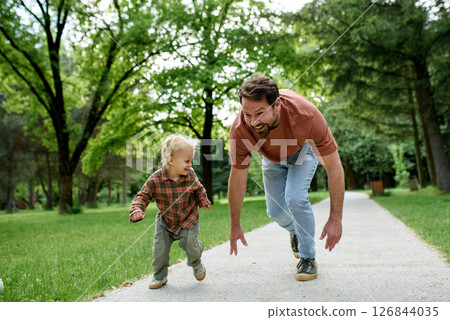 Father lining up to have a running race with his little son. 126844035