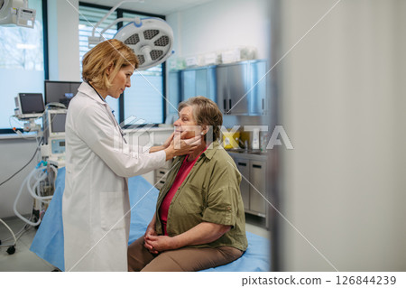 Doctor palpating lymph nodes during medical examination of senior patient. Doctor palpating lymph nodes during medical examination of senior patient. 126844239