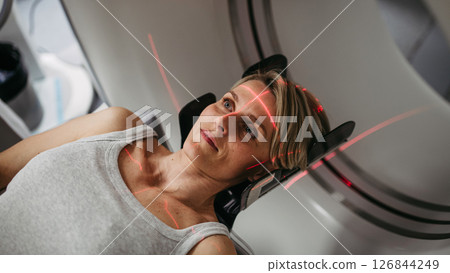 Patient positioned for head scan with laser alignment in CT scanner 126844249