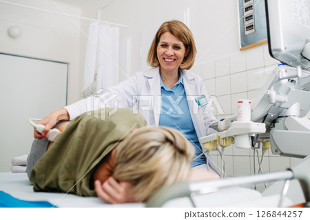 Medical examination with ultrasound probe on lower back 126844257