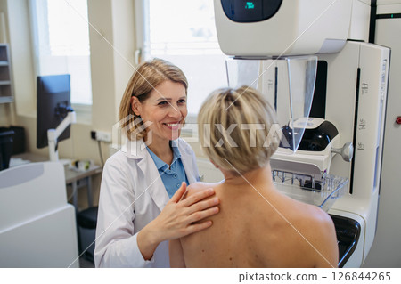 Healthcare professional adjusts the patient for accurate breast imaging. 126844265