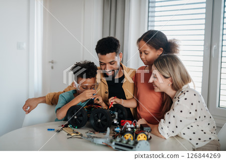 Parents encouraging children to explore robotics and technical skills. 126844269