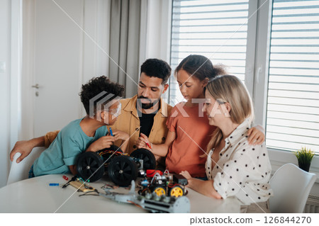 Parents encouraging children to explore robotics and technical skills. 126844270