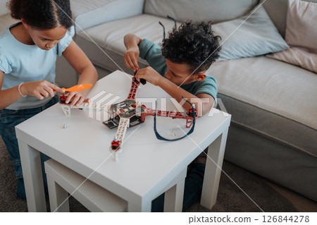 Kids playing with drone at home. 126844278