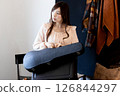 A woman with long hair holding a violin case 126844297
