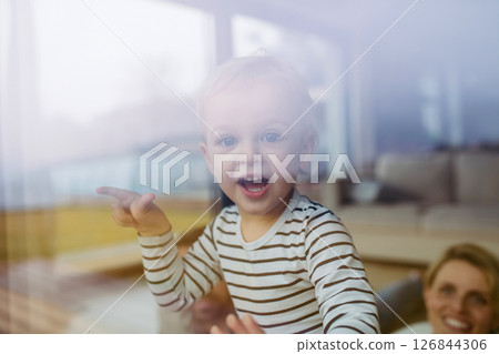Cute boy looking out of window, laughing. 126844306