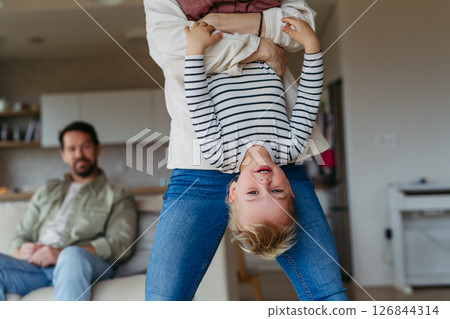 Playful father holding little son upside down. Playful father holding little son upside down. 126844314