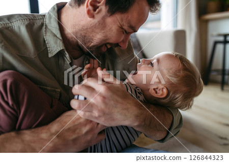 Mature father playing with little son, 126844323
