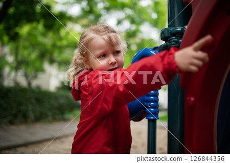 Little girl playing on outdoor playground 126844356