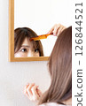 Woman who is concerned about her bangs ① 126844521