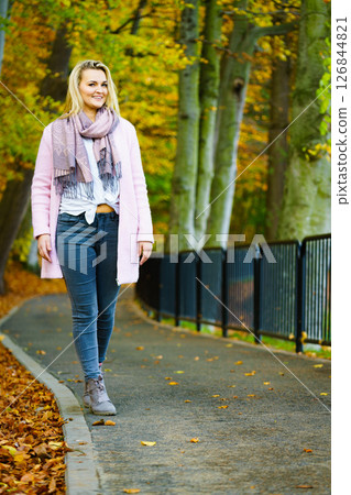 Woman walking in autumn park Woman walking in autumn park 126844821