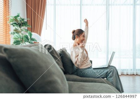 Funny euphoric young asian woman celebrating winning 126844997