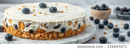 Delightful blueberry cheesecake garnished with nuts on a marble serving tray 126845071