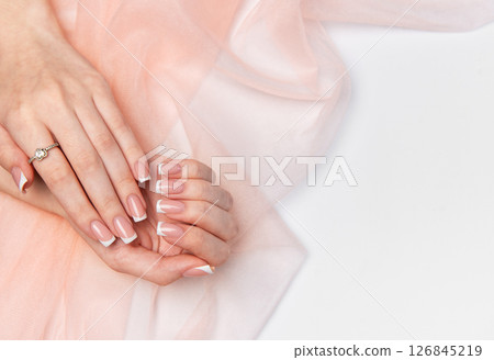 Woman showing french manicure on pink background Woman showing french manicure on pink background 126845219