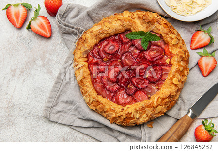 Delicious homemade strawberry galette with almond petals and fresh mint Delicious homemade strawberry galette with almond petals and fresh mint 126845232