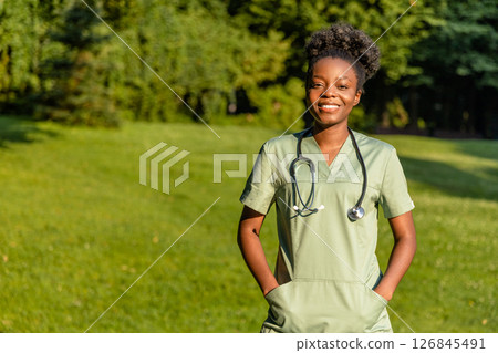 African american young woman in lab coat and stethoscope around her neck in the park 126845491