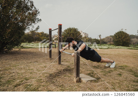 Man Does Push Ups Sport Exercise In The Park Using The Iron Bar Man Does Push Ups Sport Exercise In The Park Using The Iron Bar 126845560