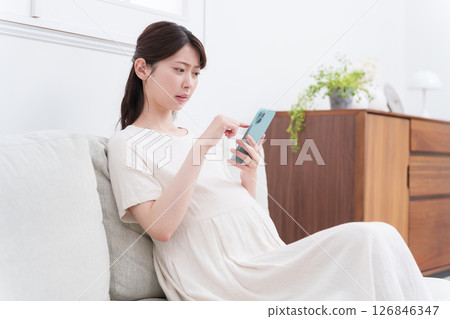Pregnant woman using a smartphone (worrying/thinking) 126846347