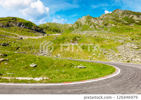 romania travel landscape with road in summer. spectacular transfagarasan road trip at high altitude. touristic destination of europe. sunny day with blue sky and fluffy clouds 126846979