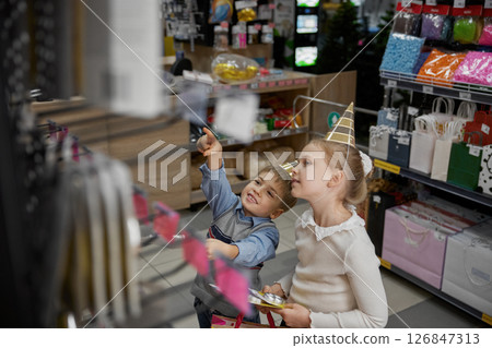 Little boy and girl kids choosing candles for birthday party at supermarket 126847313