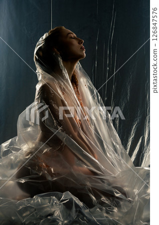 Red naked woman with gold bodyart posing under translucent film backdrop Red naked woman with gold bodyart posing under translucent film backdrop 126847576