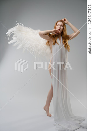 Red nude woman with angel wings posing elegantly in a modern studio setting Red nude woman with angel wings posing elegantly in a modern studio setting 126847591
